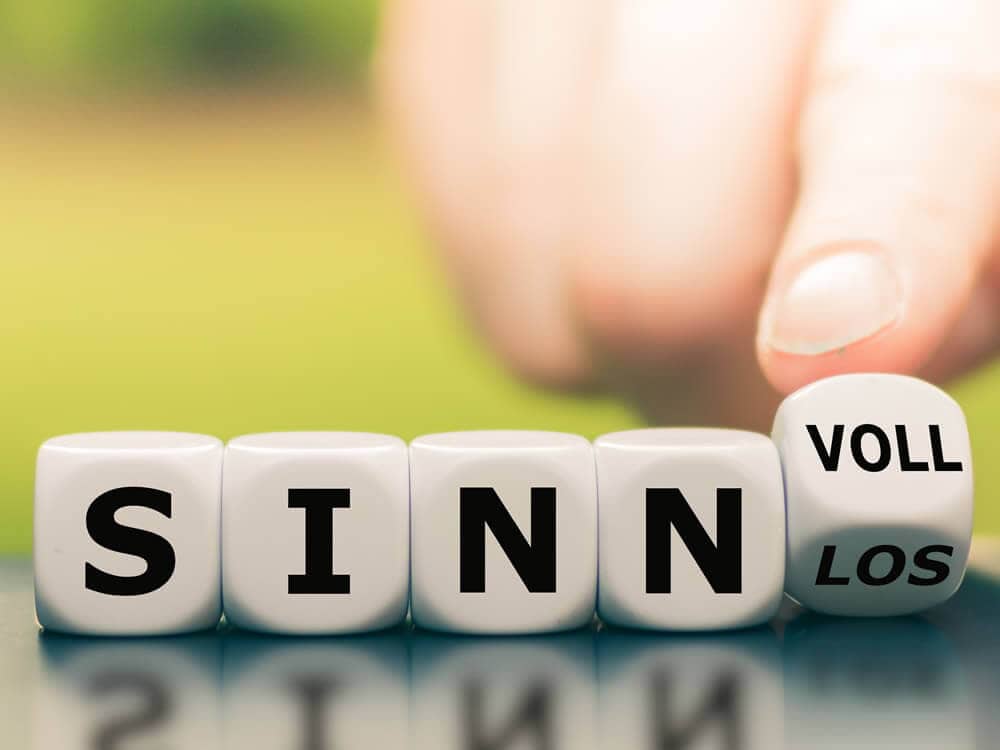 Eine Hand ordnet Würfel so an, dass sie „sinnvoll" oder "sinnlos“ darstellen. Dies gilt es bei der Anschaffung einer Kapitalanlage-Immobilie besonders zu prüfen.