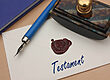 Füllfederhalter mit versiegeltem Umschlag mit der Aufschrift „Testament“ auf einem Schreibtisch.