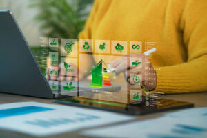 Eine Person benutzt ein Tablet und einen Stift und interagiert mit digitalen Symbolen, die Energieeffizienz, umweltfreundliche Konzepte und die Grundsätze des Gebäudeenergiegesetzes darstellen und auf dem Bildschirm eingeblendet werden.
